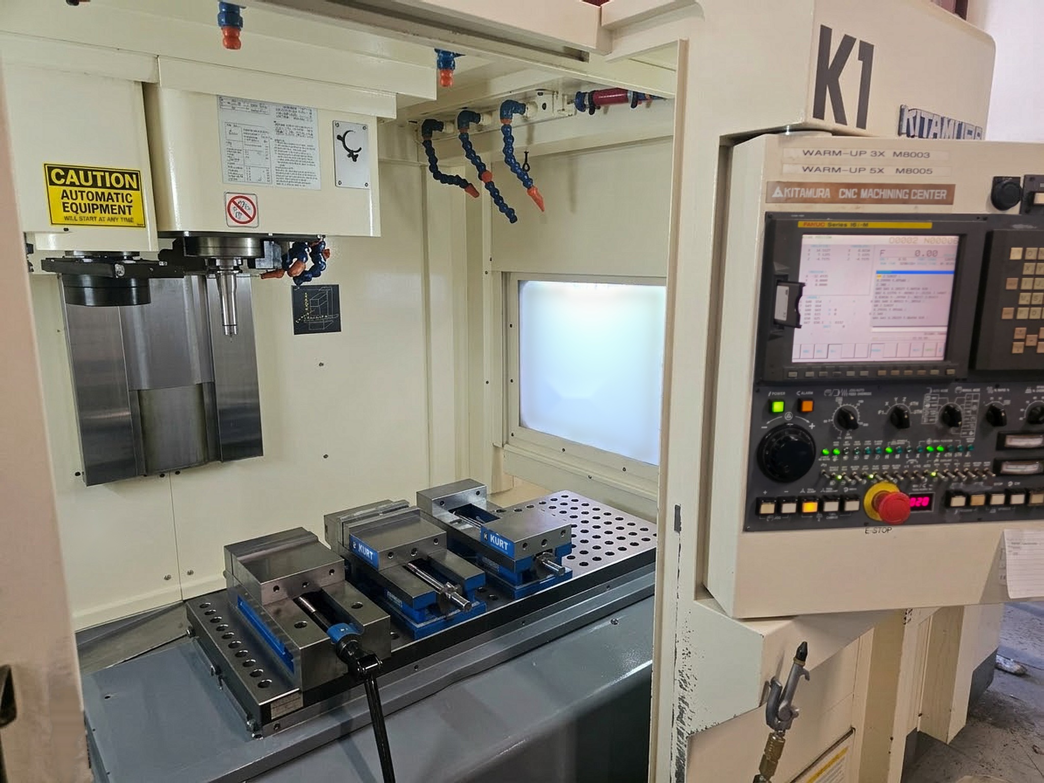 Kitamura Mycenter-4XiF with open work area, three vises and control panel